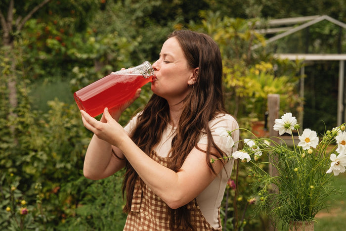 Merel drinkt zelfgemaakte kombucha uit een beugelfles