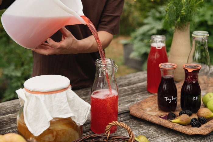 Kombucha met fruitsap in een beugelfles gieten