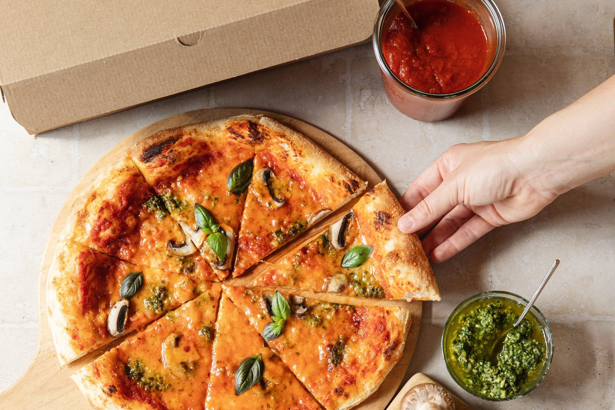 Zelfgemaakte pizza in punten naast een pizzadoos van De Groene Makers